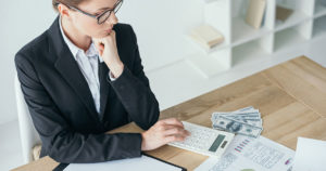 Woman calculating finances at a desk.